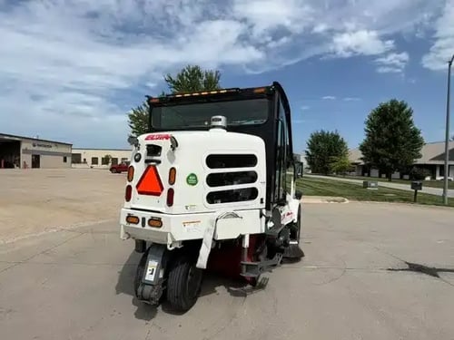 Rear passenger-side view of a 2018 Elgin Pelican NP street sweeper.
